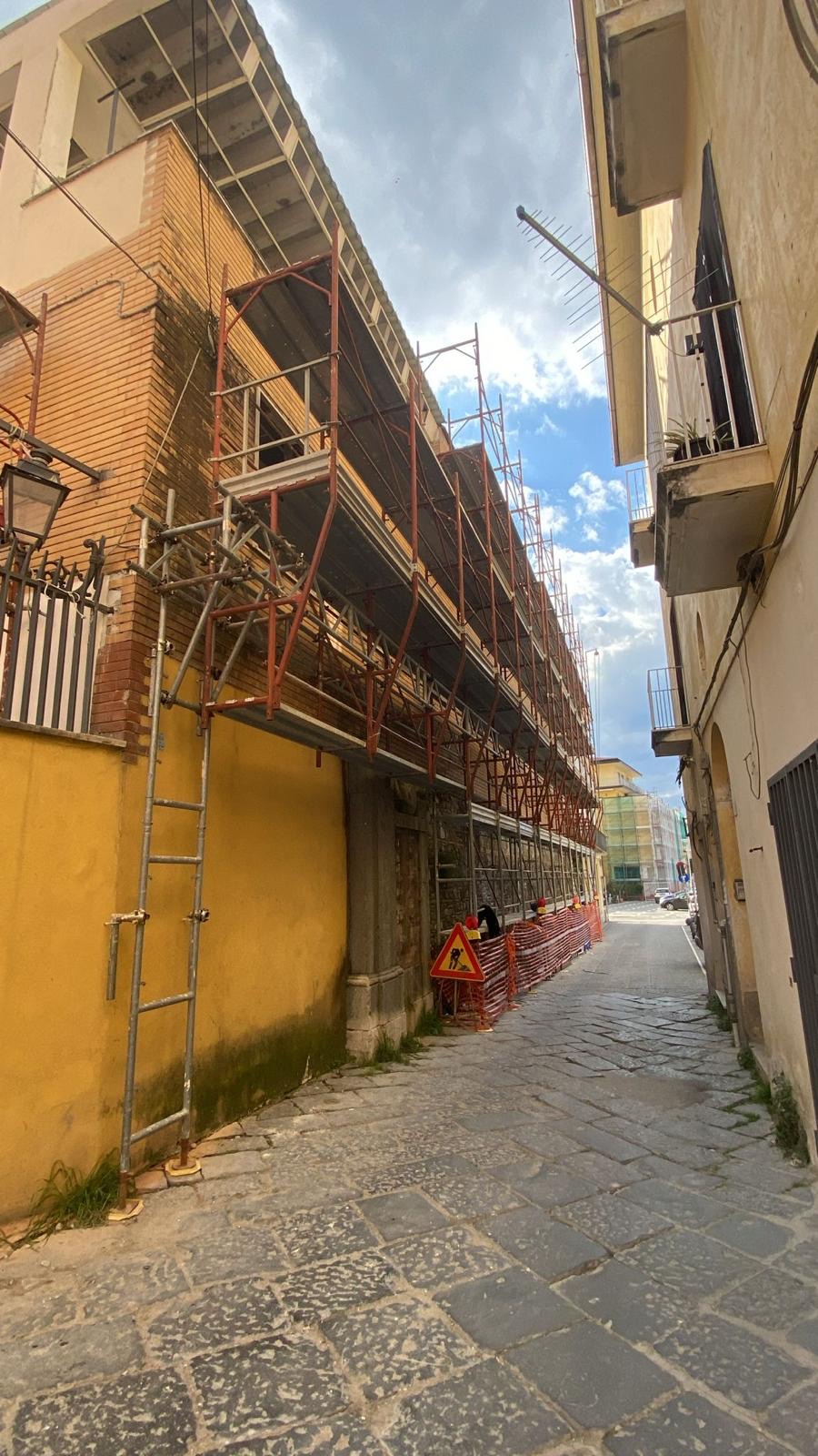 Struttura di ponteggio parzialmente sospesa in un vicolo